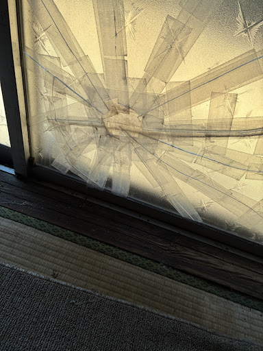 空き家・割れた窓ガラス、テープで応急処置された窓ガラス